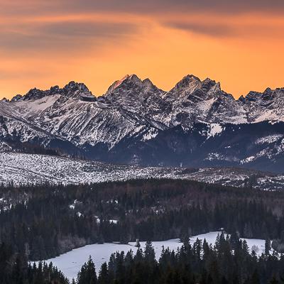 Fototapete Berge unter orangem Himmel