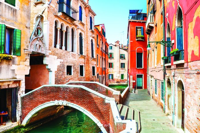 Fototapete Malerischer Kanal mit einer Brücke, umgeben von Häusern