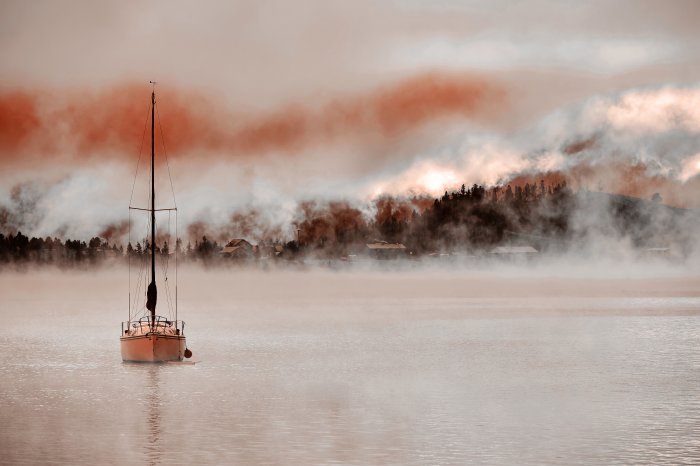 Fototapete Segelboot segelt vor dem Hintergrund eines nebligen Waldes