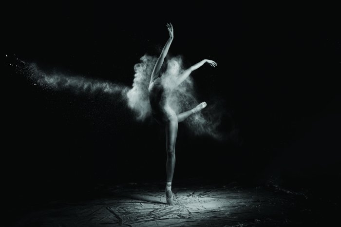 Fototapete Frau, die Ballett vor schwarzem Hintergrund tanzt