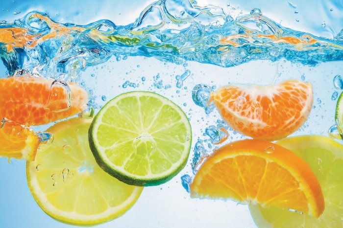 Fototapete Zitronen und Orangen, die ins Wasser fallen