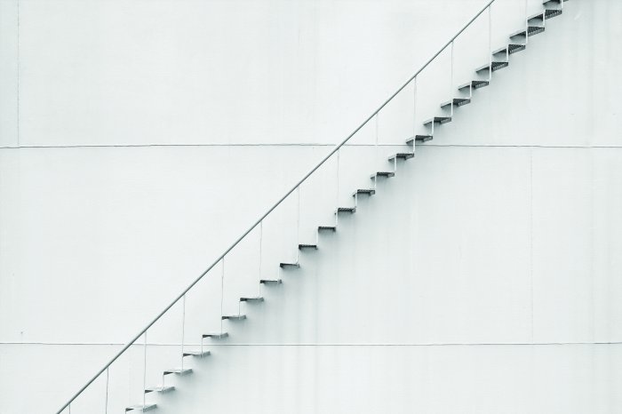 Fototapete Zarte Metallschritte an der weißen Wand