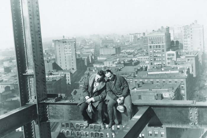 Fototapete Männer auf einer Metallkonstruktion vor der Stadtkulisse
