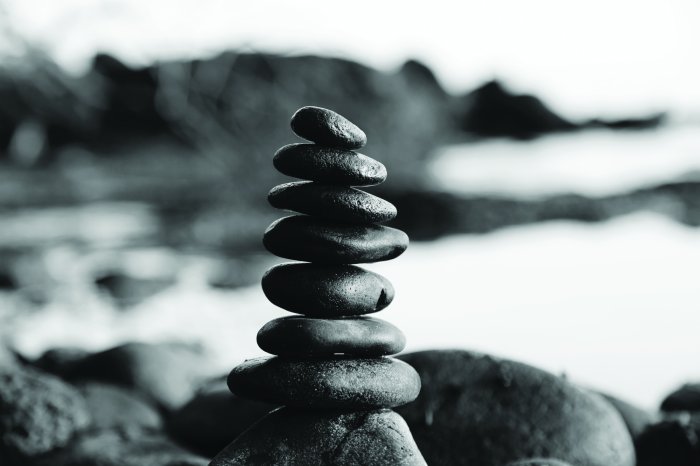 Fototapete Schwarz-weißes Muster mit Steinen vor dem Meereshintergrund