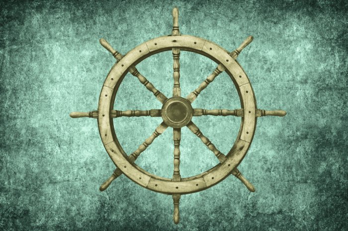 Fototapete Holzsteuerrad eines Schiffes vor einem Betonhintergrund