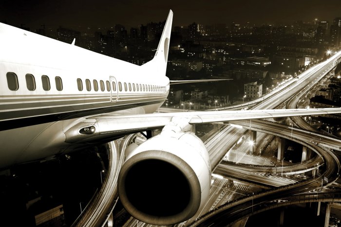 Fototapete Flugzeug vor der Stadtkulisse bei Nacht