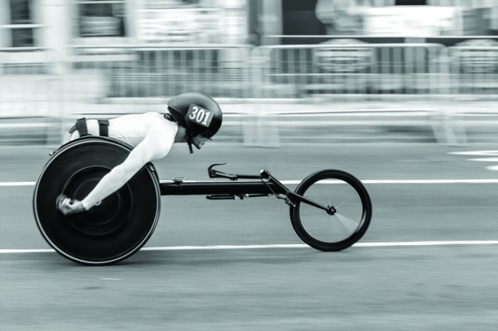 Fototapete Rennfahrer im Rennrollstuhl in voller Fahrt
