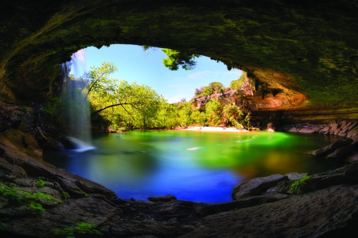Fototapete Landschaft mit Wasserfall, der in einen See mit Sandstrand mündet