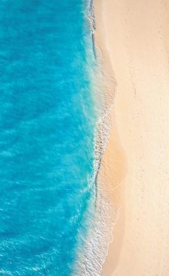 Sticker Vogelperspektive auf einen Sandstrand und türkisfarbenes Wasser