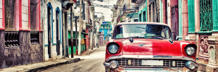 Bild Ein roter Oldtimer parkt in der Altstadt von Havanna.
