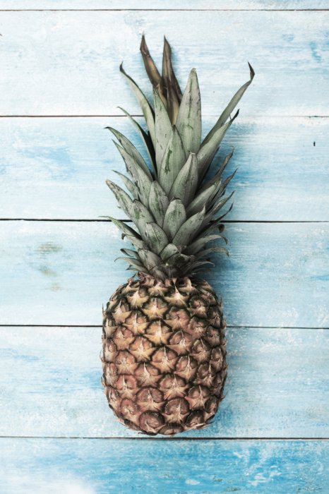 Poster Ananas auf blauem Holzhintergrund