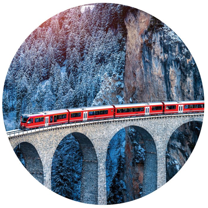 Sticker Ein Zug, der auf einem Viadukt durch die Alpen fährt