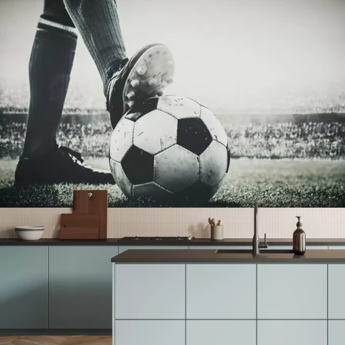 Fototapete Feet of soccer player tread on soccer ball for kick-off in the stadium black and white