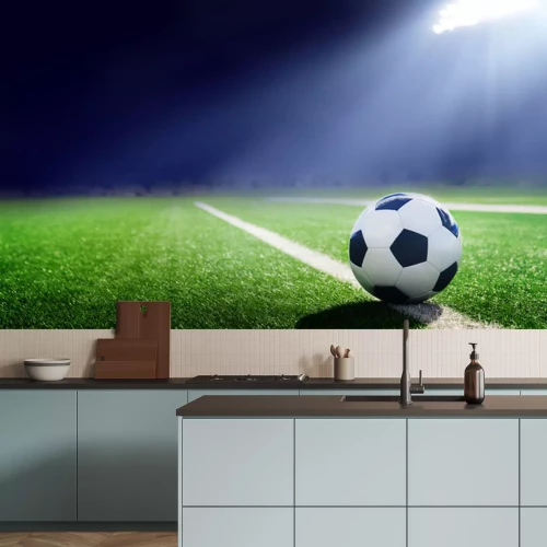 Sticker Ein Ball, der auf dem Rasen liegt und von einem Scheinwerfer beleuchtet wird