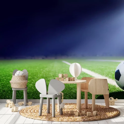 Sticker Ein Ball, der auf dem Rasen liegt und von einem Scheinwerfer beleuchtet wird