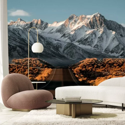 Fototapete Landschaft mit einer Straße vor dem Hintergrund schneebedeckter Berggipfel