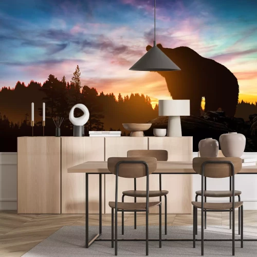 Fototapete Ein Bär in einer Landschaft mit einem Sonnenuntergang im Hintergrund