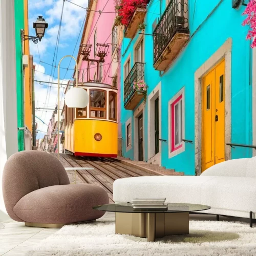 Fototapete Lisbon, Portugal - Yellow tram on a street with colorful houses and flowers on the balconies - Bica Elevator going down the hill of Chiado.