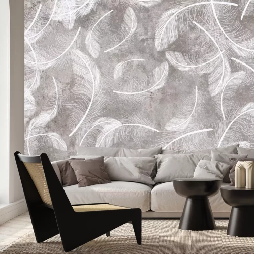 Fototapete Weiße Federn auf grauem Betongrund