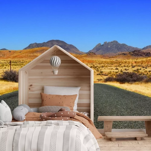 Fototapete Betonstraße, die durch die Mitte der Wüste führt