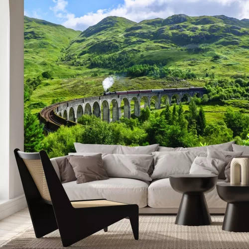 Fototapete Zug, der auf einer Brücke inmitten der Berge fährt