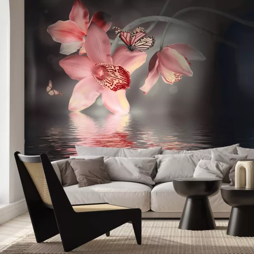 Fototapete Orchidee mit einem Schmetterling vor Wasserhintergrund
