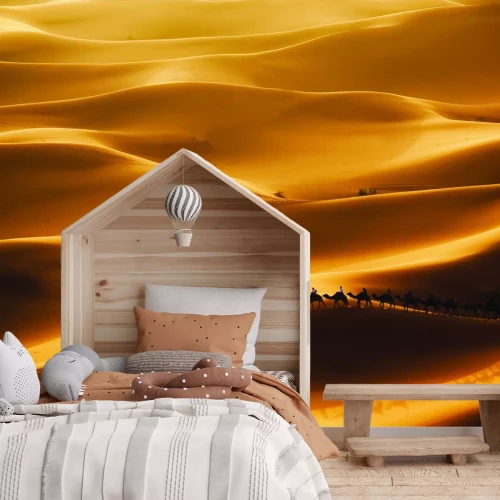 Fototapete Kamele, die durch eine große Wüste gehen