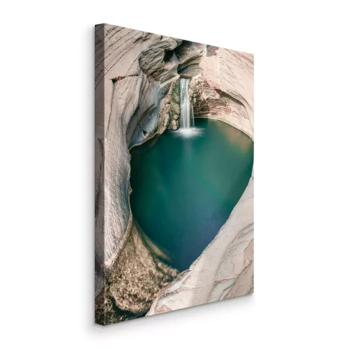 Bild Ein Wasserfall, der in ein türkisfarbenes Becken zwischen den Felsen stürzt.