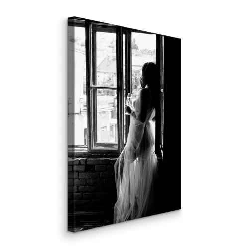 Bild Eine Frau im Kleid an einem Fenster, aufgenommen in Schwarzweiß
