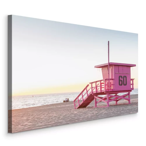 Bild Ein pastellfarbener Rettungsschwimmerstand mit Blick auf den Ozean bei Sonnenaufgang