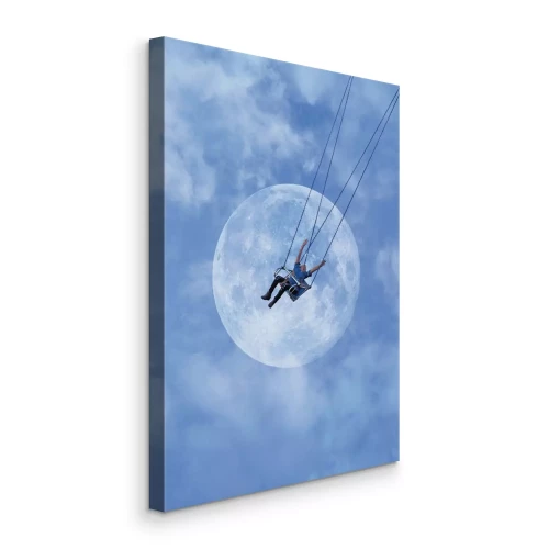 Bild Ein Mann auf einer Schaukel vor blauem Himmel mit Mond