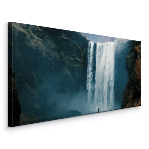 Bild Ein großer Wasserfall, der von den Felsen herabstürzt.