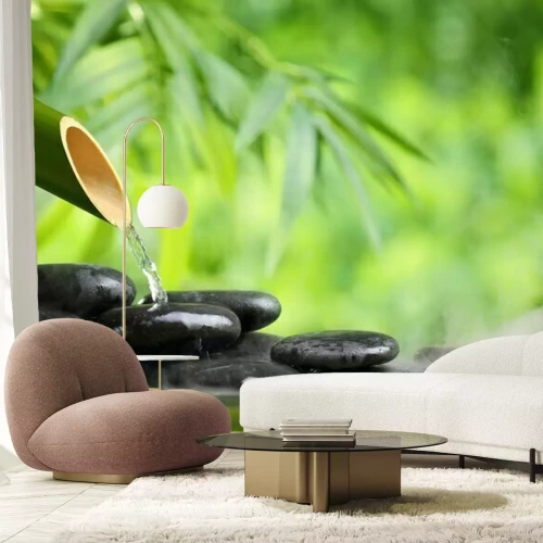 Sticker Ein Wasserstrahl aus Bambus auf schwarzen Steinen