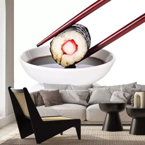 Sticker Sushi mit Stäbchen über einer Schüssel mit Sauce gehalten