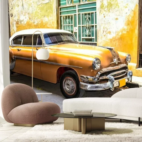 Fototapete Ein gelber Oldtimer neben Ein Mietshaus in Kuba