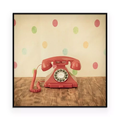 Poster Ein pinkfarbenes Retro-Telefon vor einer gepunkteten Wand