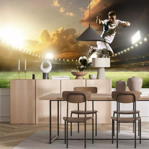 Fototapete Ein Fußballspieler in Aktion in einem Stadion mit Flutlicht