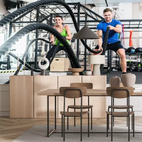 Fototapete Eine Frau und ein Mann trainieren im Fitnessstudio mit einem Seil