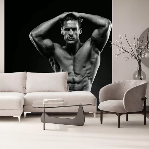 Fototapete Ein muskulöser Mann auf schwarzem Hintergrund