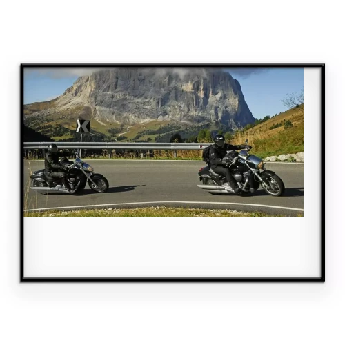 Poster Motorradfahrer auf der Straße vor einem Berg im Hintergrund