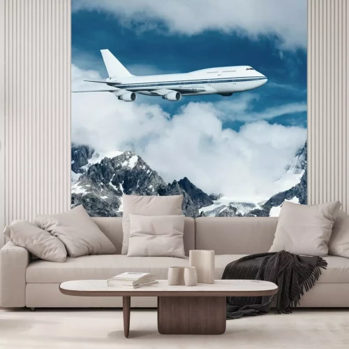 Fototapete Ein Passagierflugzeug über schneebedeckten Bergen