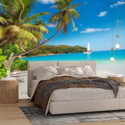 Fototapete Sandstrand mit Palmen und ein Segelboot im türkisblauen Meer auf der Insel Paradise.