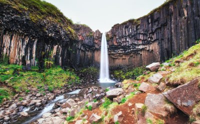Fototapete Landschaft mit Wasserfall inmitten der Felse