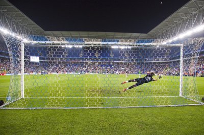 Fototapete Ein Torwart hechtet in der Abwehr nach dem Ball