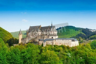 Fototapete Schloss inmitten von grünen Bergen