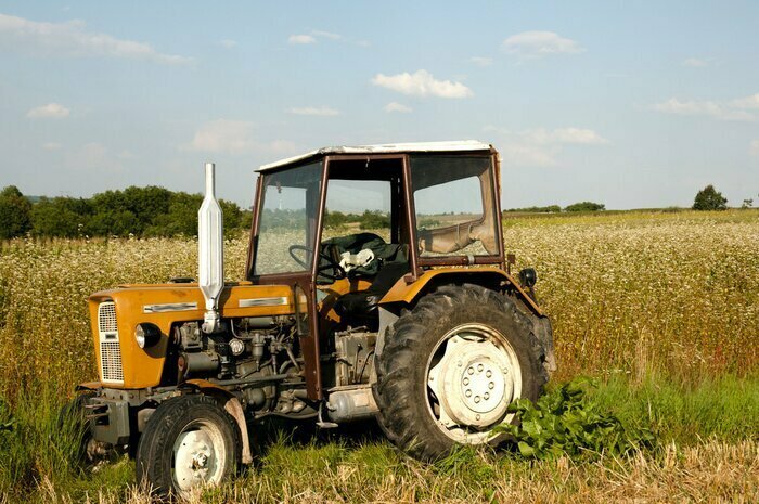 Sticker Alter Traktor, der auf einem ländlichen Feld arbeitet